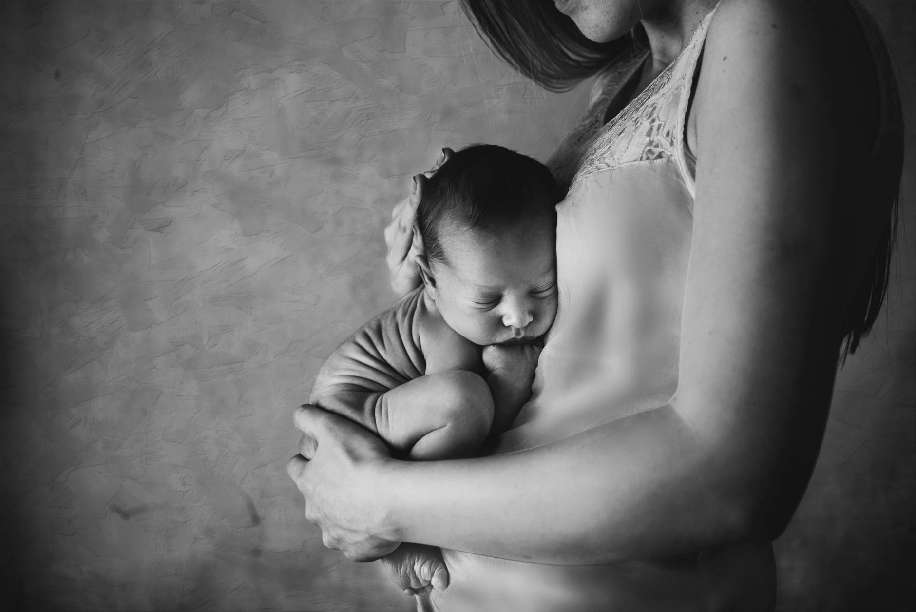 tender black and white mother holding newborn